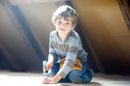 Little kid boy helping with toy tools on construciton site.の写真素材