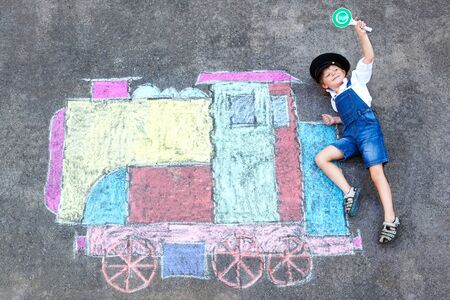 little kid boy having fun with train chalks pictureの写真素材