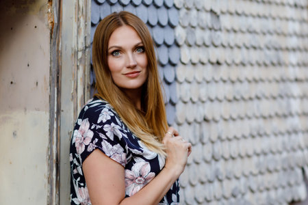 Beautiful young woman with long hairs in summer dress going for a walk in German city. Happy girl enjoying walking in cute small fachwerk town with old houses in Germany.の写真素材