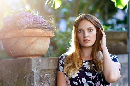 Beautiful young woman with long hairs in summer dress going for a walk in German city. Happy girl enjoying walking in cute small fachwerk town with old houses in Germany.の写真素材