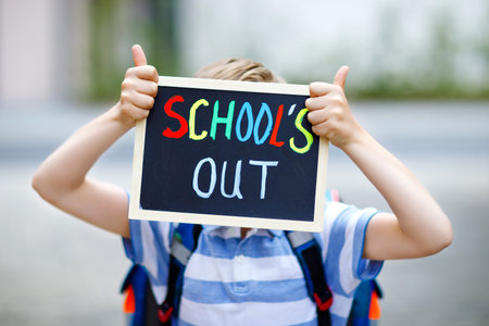 Happy little kid boy with backpack or satchel. Schoolkid on the way to school. Healthy adorable...