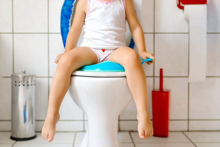 Closeup of cute little toddler baby girl child sitting on toilet wc seat. Potty training for small children. Unrecognizable face of childの写真素材