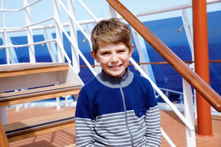 Portrait of happy little kid boy on cruise ship. Funny beautiful child making family vacations.の写真素材