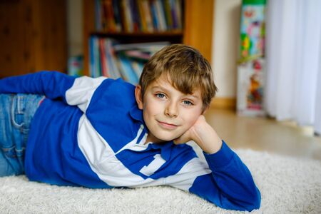 Portrait of little happy cute school kid boy at home. Beautiful happy child looking at the camera. Schoolboy having fun. Education concept.の写真素材