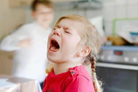 Cute upset unhappy toddler girl crying. Angry emotional child shouting. Portrait of kid with tears.の写真素材