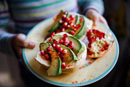 Healthy homemade sandwich with avocado and pomegranate for breakfast. Vegan or vegetarian meal.