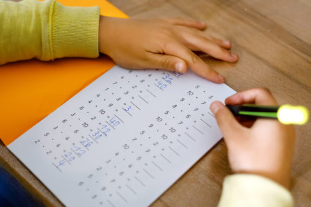 school kid making mathematics homework during quarantine from corona pandemic disease. child...