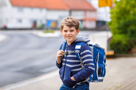 Happy little kid boy with backpack or satchel. Schoolkid on way to elementary school. Healthy adorable child outdoors. Back to school after quarantine time from corona and covid 19 pandemic diseaseの写真素材