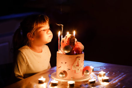 Adorable little toddler girl celebrating fourth birthday. Cute toddler child with homemade princess...
