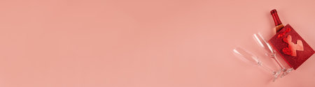 Happy Valentines Day banner. Top view bottle of rose champagne in gift box, hearts, glasses on soft pink background. Valentine day or New Year greeting cardの写真素材