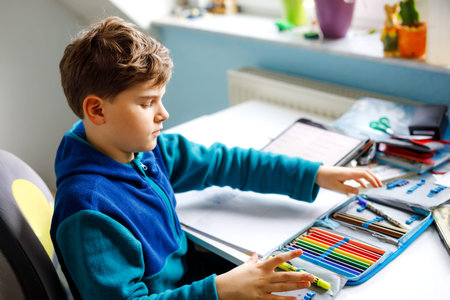 School kid boy getting ready in the morning for school. Healthy child filling satchel with books,...