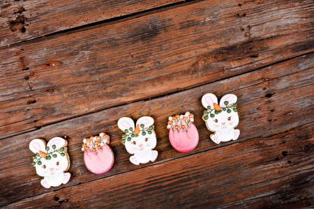 Closeup of variation of different Easter sugar cookies decorated with royal icing. Bunny rabbit with carrots and eggs on wooden background. Lovely sweet gift or postcardの写真素材