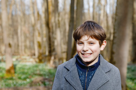 Portrait of preteen school kid boy. Happy smiling child looking at the camera. Boy in spring forest,...