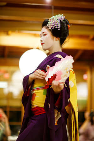 KYOTO, JAPAN - 18 May, 2015: Maiko apprentice showing Japanese traditional dance. Maiko is an apprentice geisha. Maikos performing songs, playing shamisen or instruments for visitors on ozashiki.のeditorial素材