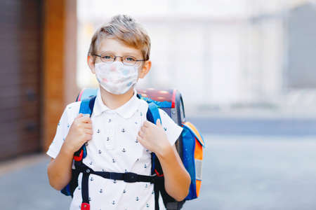 Happy little kid boy with glasses and backpack or satchel. Schoolkid on the way to school. Portrait of healthy adorable child outdoors. Student, pupil, back to school. Elementary school ageの写真素材