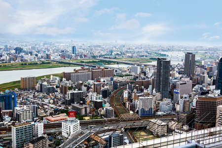 OSAKA,JAPAN - 18 May, 2015: View from above on Osaka city with skyline with skycrapers, highways and parks from top of Osaka castle in Japan. It is the capital city of Osaka Prefecture.のeditorial素材