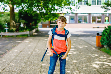 Kid boy with medical mask on the way to school. Child with backpack satchel. Back to school after...