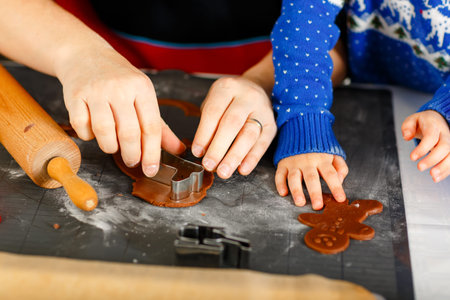 Close-up of hands of little preschool boy and father baking gingerbread cookies. Close up of son and...