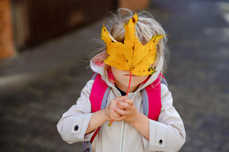 Cute little toddler girl on her first day going to playschool. Healthy happy child walking to nursery school. Kid with backpack going to day care on the city street, outdoorsの写真素材