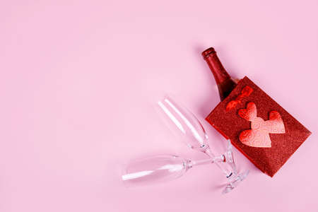 Happy Valentines Day flatlay. Top view bottle of rose champagne in gift box, hearts, glasses on soft pink background. Valentine day or New Year greeting cardの写真素材