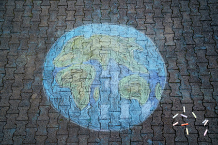 Earth globe painting with colorful chalks on ground. PHappy earth day concept. Creation of children...