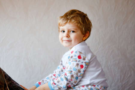Portrait of happy smiling toddler boy indoors. Little preschool child with blond hairs looking at the camera.の写真素材