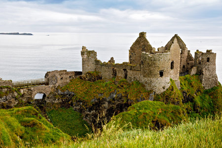 Ruins of Dunluce Castle, Antrim, Northern Ireland during sunny day with semi cloudy sky. Irish ancient castle near Wild Atlantic Way.の写真素材