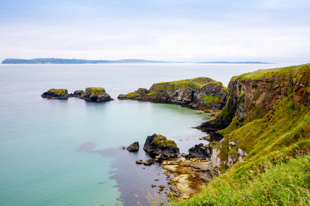 Coast near Carrick-a-Rede Rope Bridge, famous rope bridge near Ballintoy in County Antrim, Northern Ireland on Irish coastline. Wild Atlantic Way on cloudy day.の写真素材