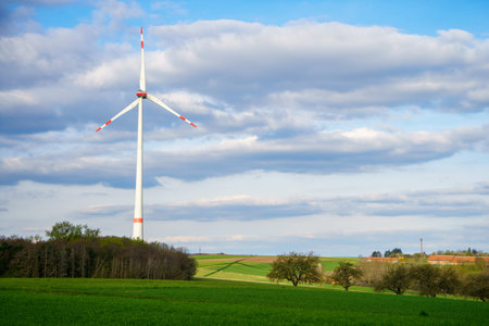Panoramic view of wind farm or wind park on sunny day, with high wind turbines for generation...