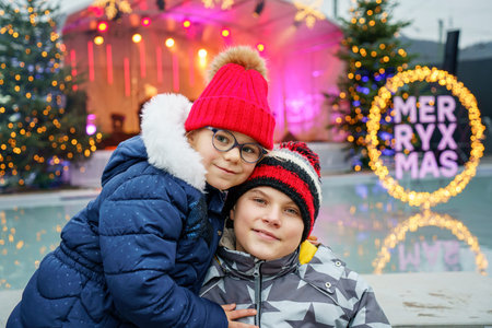 Two little smiling kids, boy and girl with christmas tree. Happy children in winter clothes on...