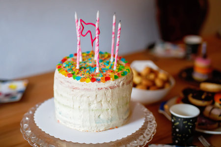 Closeup of homemade rainbow cake with 6 candles.