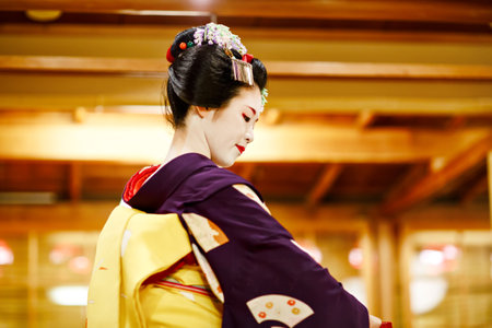 KYOTO, JAPAN - 18 May, 2015: Maiko apprentice showing Japanese traditional dance. Maiko is an apprentice geisha. Maikos performing songs, playing shamisen or instruments for visitors on ozashiki.のeditorial素材