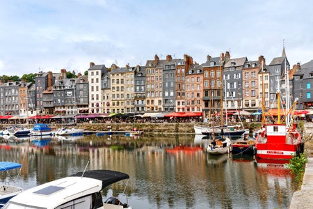 HONFLEUR, FRANCE - August 23, 2022: View of the picturesque harbour of Honfleur, yachts and old houses reflected in waterのeditorial素材