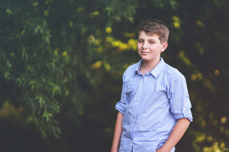 Handsome Teenager Boy Poses Outdoors, Exuding Confidence and Style in a Captivating Portrait. Happy...