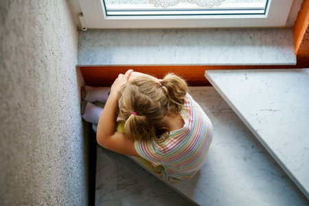 Lonely Upset Little Preschool Girl at Home. Sad Child Alone. Emotional Stress of Children, School, and Family Problems.の写真素材