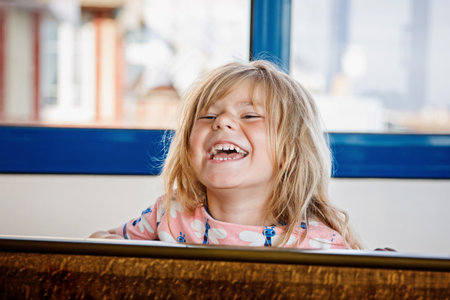 Little preschool girl playing table soccer. Happy excited positive child having fun with family game with siblings or friends.の写真素材