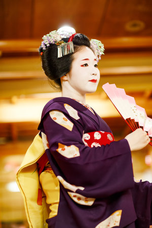 KYOTO, JAPAN - 18 May, 2015: Maiko apprentice showing Japanese traditional dance. Maiko is an apprentice geisha. Maikos performing songs, playing shamisen or instruments for visitors on ozashiki.のeditorial素材