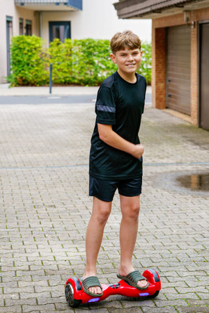 Active preteen kid boy on hover board. Teenager Child driving modern balance hoverboard. Excercise...