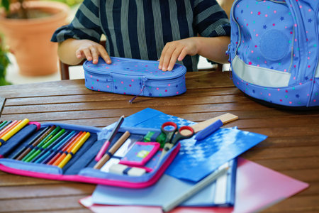 Happy smiling girl preparing for school her backpack. First day of school. Back to school concept....