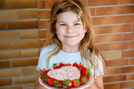 cute fashion little girl eat happy birthday pink cupcakeの写真素材