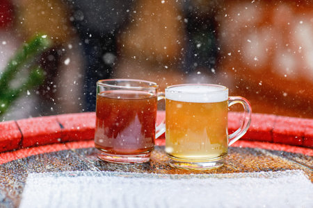 Two glasses mugs with red and white mulled wine on Christmas market in Germany. Traditional...