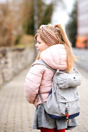 Cute little preschool girl going to playschool. Healthy toddler child walking to nursery school and...