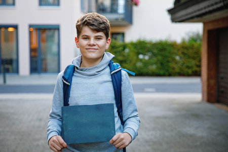 Happy teenager boy with backpack.. Schoolkid on the way to middle or high school. Excited child outdoors on school yard. Back to school. Kid holding chalk desk with copyspace for textの写真素材