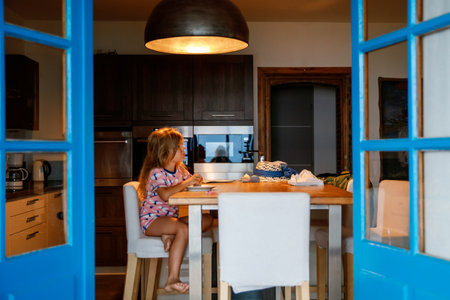 Three children watching sunrise on terrace or balcony. Two kids boys and preschool girl watch sun on horizon. Happy children relaxing near beach, family enjoying beautiful view.の写真素材