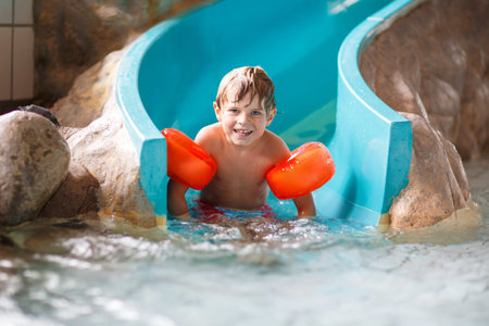 Active adorable little preschool kid boy with swimmies learning to swim in an indoor pool. Active...