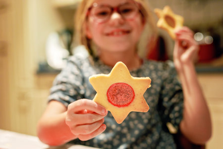 Little girl baking Christmas cookies at home. Happy child and gingerbread cookie