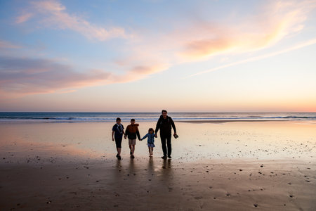 Portrait silhouettes of three children and dad happy kids with father on beach at sunset. happy family, Man, two school boys and one little preschool girl. Siblings having fun together. Bondingの写真素材