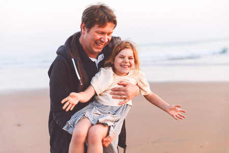 Healthy loving father and daughter playing together at the beach at sunset Happy family, love....