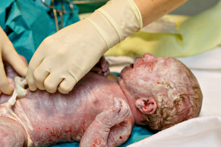 Newborn child crying seconds and minutes after birth. Cute tiny new born baby girl on towel. New life, beginning, healthcare.の写真素材