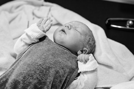 Newborn child crying seconds and minutes after birth. Cute tiny new born baby girl on towel. New life, beginning, healthcare.の写真素材